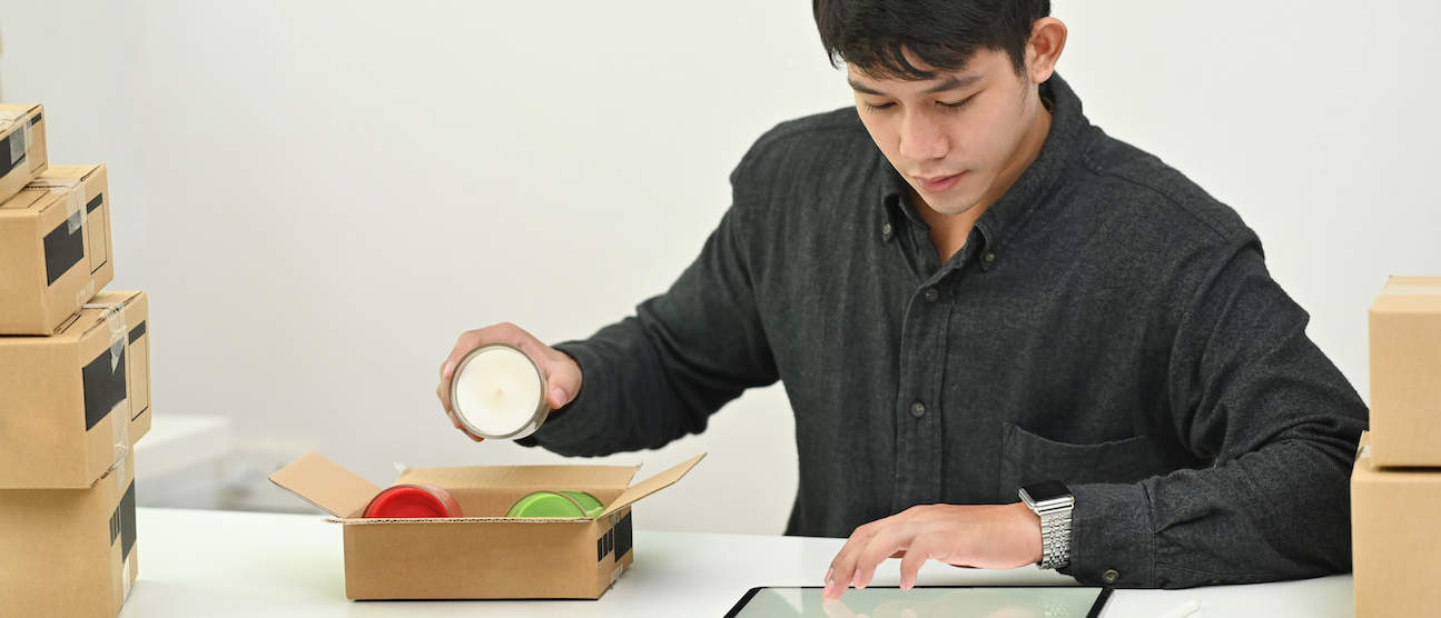 person packing candle into box