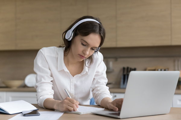 woman listening to medi on her laptop with headphones